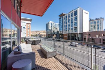 A rooftop patio with a couch and a table.